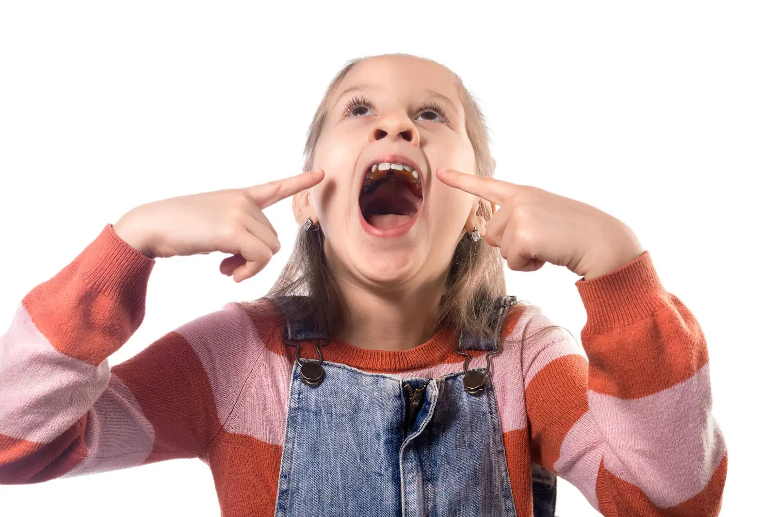 Young girl pointing to her open smile